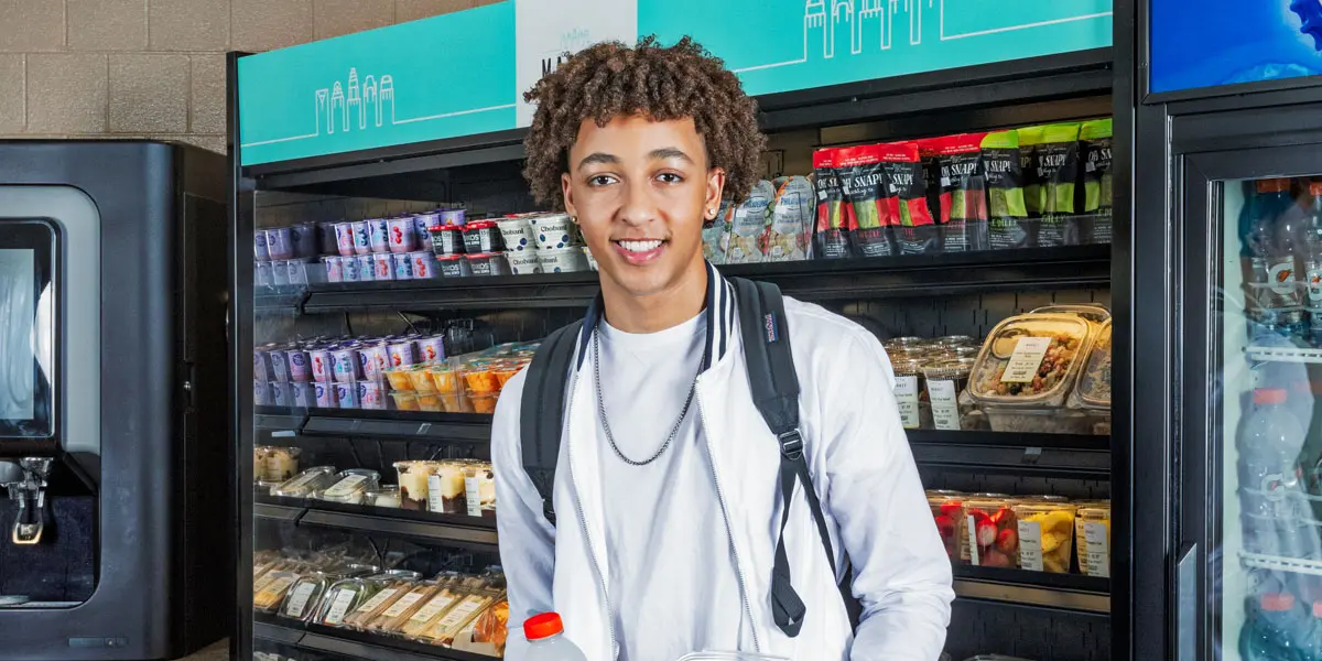 Student smiling in middle of c-store